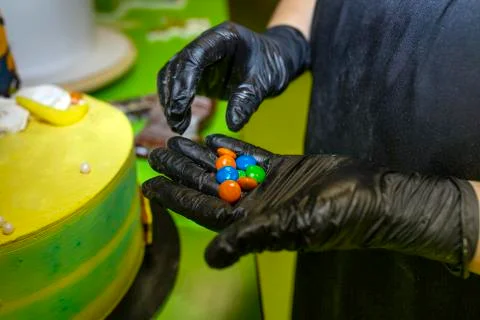 Pastry chef decorating cake in the kitchen. Colorful decorations Stock Photos