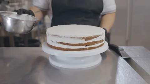 Pastry chef decorating cake with liquid pouring it on top of cake Stock Footage 125050297