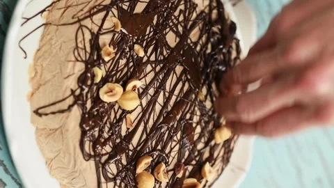 The pastry chef decorating chocolate semifreddo with hazelnuts. Vertical video. Stock Footage 305154791