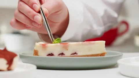 Pastry chef decorating classic dessert cheesecake with strawberry filling by Stock Footage 278918015