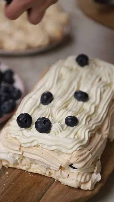 Pastry chef decorating meringue cake with blueberries Stock Footage 343678945