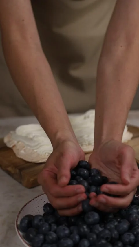 Pastry chef decorating meringue cake with blueberries Stock Footage 343678978