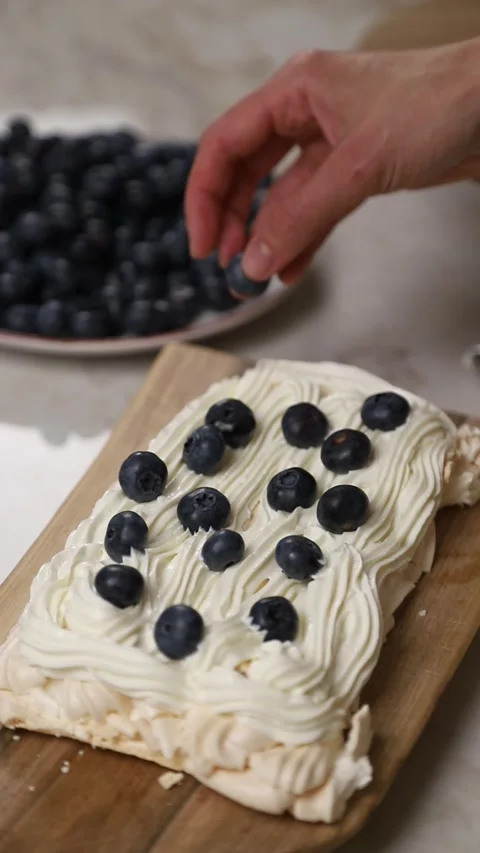 Pastry chef decorating meringue cake with blueberries Stock Footage 343679042