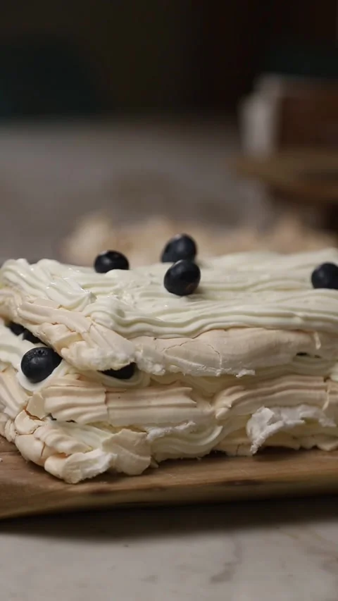 Pastry chef decorating meringue cake with blueberries Stock Footage 343679055