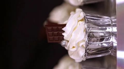 Pastry chef decorating sweet cupcake with whipped cream and chocolate with beads Stock Footage 297850150