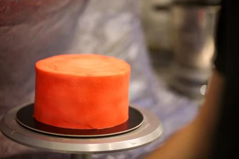 Pastry chef designer using edible red paint airbrush to spray frosted cup cak Stock Photos