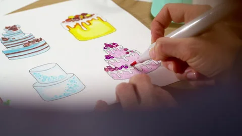 The pastry chef develops a cake design by drawing on paper.  Stock Footage 253318585