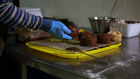 The pastry chef dips the cake into liquid chocolate   库存影片 106480532
