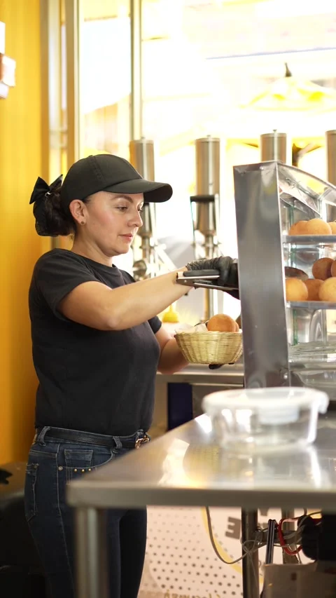 Pastry Chef Displaying Fresh Cheese Buns or bunuelos in a Showcase for Sale Stock Footage 286168862