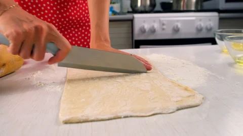 Pastry chef dividing dough cutting with knife on kitchen table cooking dessert. Stock Footage 313040995