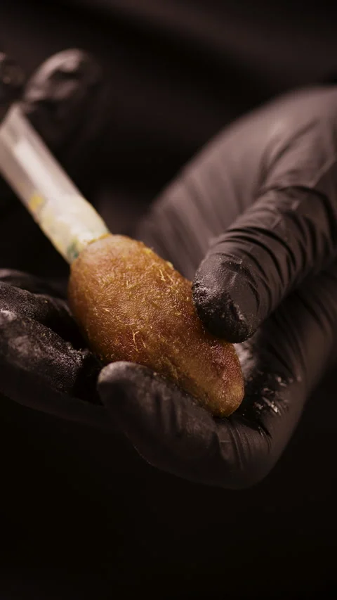 Pastry chef filling a large dried date with nut paste using a syringe, close-up Stock Footage 307017282