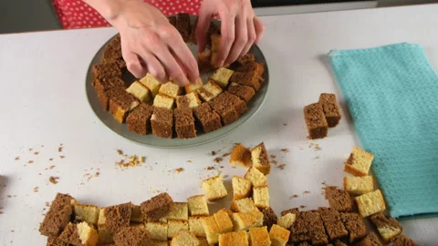 Pastry chef hands arranging small chocolate and vanilla cake cubes on plate. Stock Footage 311536383