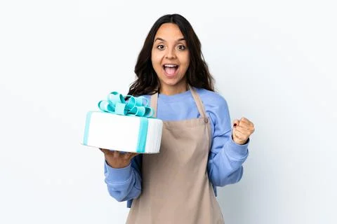Pastry chef holding a big cake over isolated white background celebrating a v Stock Photos
