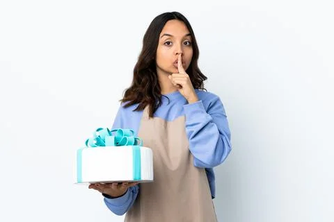 Pastry chef holding a big cake over isolated white background showing a sign  Stock Photos
