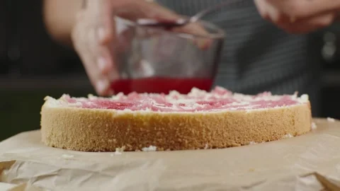 Pastry chef impregnates a fresh sponge cake with syrup a cake Stock Footage 286302734