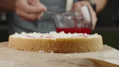 Pastry chef impregnates a fresh sponge cake with syrup a cake Stock Footage 286302768