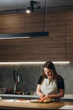 Pastry chef in the kitchen decorating a cake of chocolate,fruit,candies,Confe Stock Photos