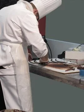 Pastry chef in the kitchen preparing chocolate decoration on a worktop Stock Photos