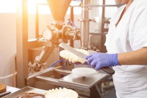 The pastry chef makes cake using modern equipment for the production of cakes Foto stock