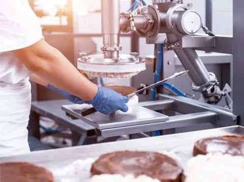 The pastry chef makes cake using modern equipment for the production of cakes Foto stock