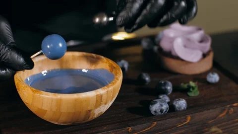 Pastry chef is making artificial berry for topping a blueberry cake, close-up Video stock 124892653