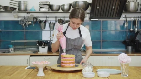 Pastry chef making cake of sponge layers and pink cream Stock Footage 108875130