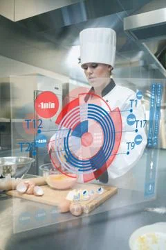 Pastry chef making dough while consulting futuristic interface Foto stock
