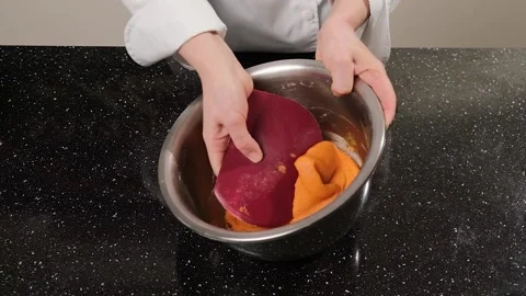 The pastry chef mixes the dough for the macarons in a stainless steel bowl. Stock Footage 149595075