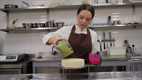 The pastry chef pours liquid green pistachio syrup onto a mousse cake. Stock Footage 171105772