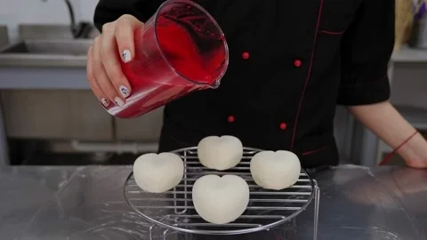 The pastry chef pours liquid syrup on mousse cakes. Desserts with mirror glaze. Stock Footage 136834036