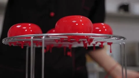 The pastry chef pours liquid syrup on mousse cakes. Desserts with mirror glaze. Stock Footage 136834827