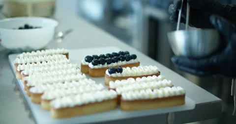 A pastry chef prepares a dessert in a pastry shop. Close-up of hands. Vídeo Stock 133739447