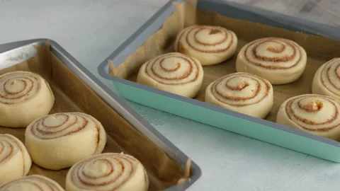 Pastry chef prepares raw cinnabons. Female hands preparing cinnabon on the table Stock Footage 141371028