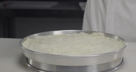 Pastry chef prepares Turkish dessert baklava using traditional recipe, sprinkle Stock Footage 289568116