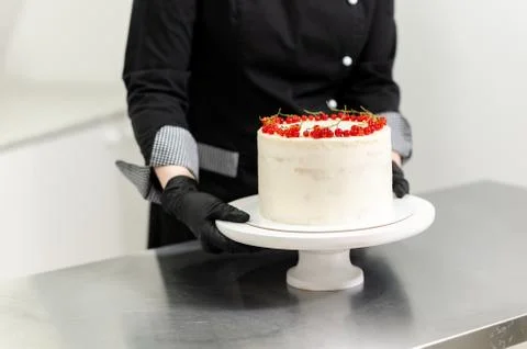 Pastry chef preparing a cake with red currants Stockfoto's