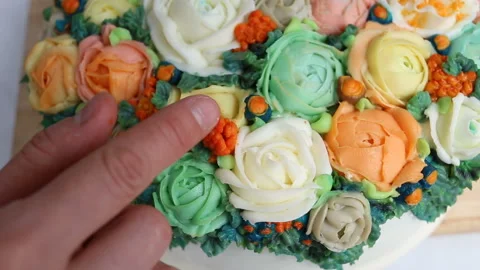 The pastry chef puts a bright orange berry on the cake. Bright elegant cake deco Stock Footage 143729683
