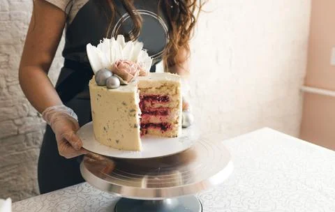 The pastry chef puts a large cake on the stand. Stock Photos