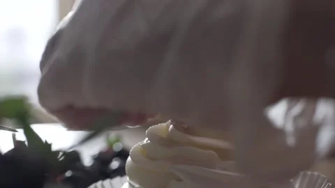 The pastry chef puts raspberry on a small cream cake extreme close up Video stock 130356649