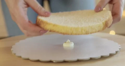 Pastry chef is putting cake sponge on cream to make a cake, hands closeup. Stock Footage 131230647