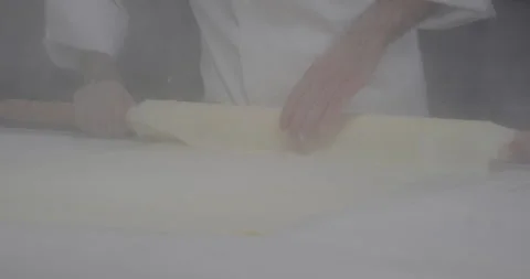 Pastry chef roll out phyllo dough with a rolling pin sprinkle flour. Turkish Stock Footage 281515451