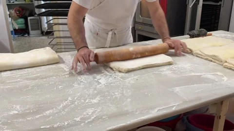 Pastry Chef Rolling Puff Pastry in a Traitional Bakery on a White Marble Table Stock Footage 304489941