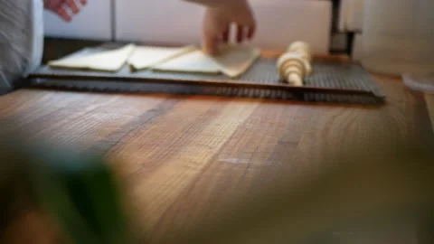 A pastry chef rolls out flour dough while making sweet buns at a bakery Stock Footage 145711331