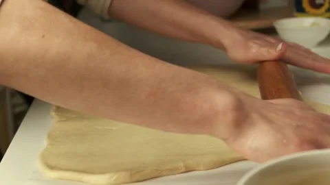 Pastry chef rolls out yeast dough using a rolling pin Stock Footage 320132037