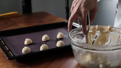 Pastry chef scooping cookie dough in to baking tray. Stock-Footage 146470032