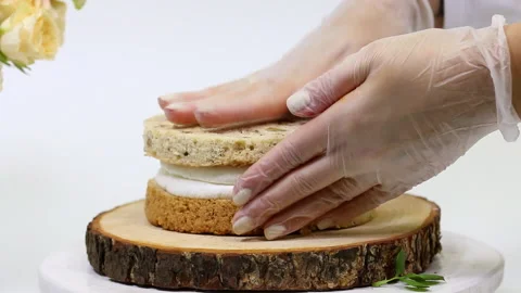 Pastry chef squeezes white cream from a pastry bag onto the cake close-up Stock Footage 149840418