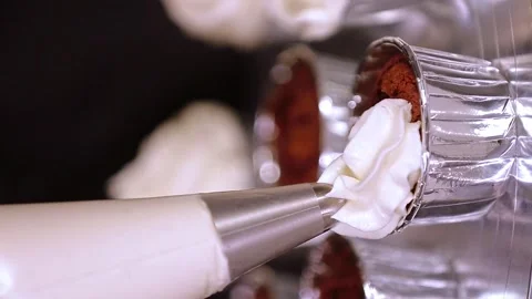 Pastry chef squeezing whipped cream onto cupcakes, vertical video Stock Footage 297624183