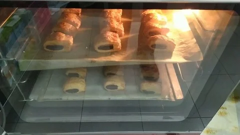 Pastry chef taking freshly made chocolate buns from the oven. Stock Footage 125612583