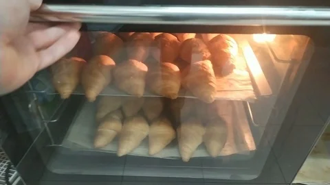 Pastry chef taking freshly made croissants from the oven. Stock Footage 125612614