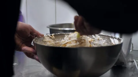Pastry chef using spoon to mix airy dough with almond flour in bowl in kitchen. Stock Footage 309312672