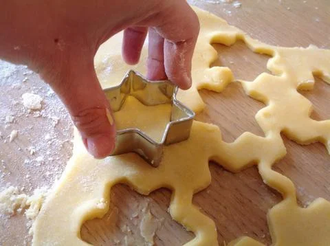Pastry chef using star shaped cookie cutter, making christmas cookies Stock Photos